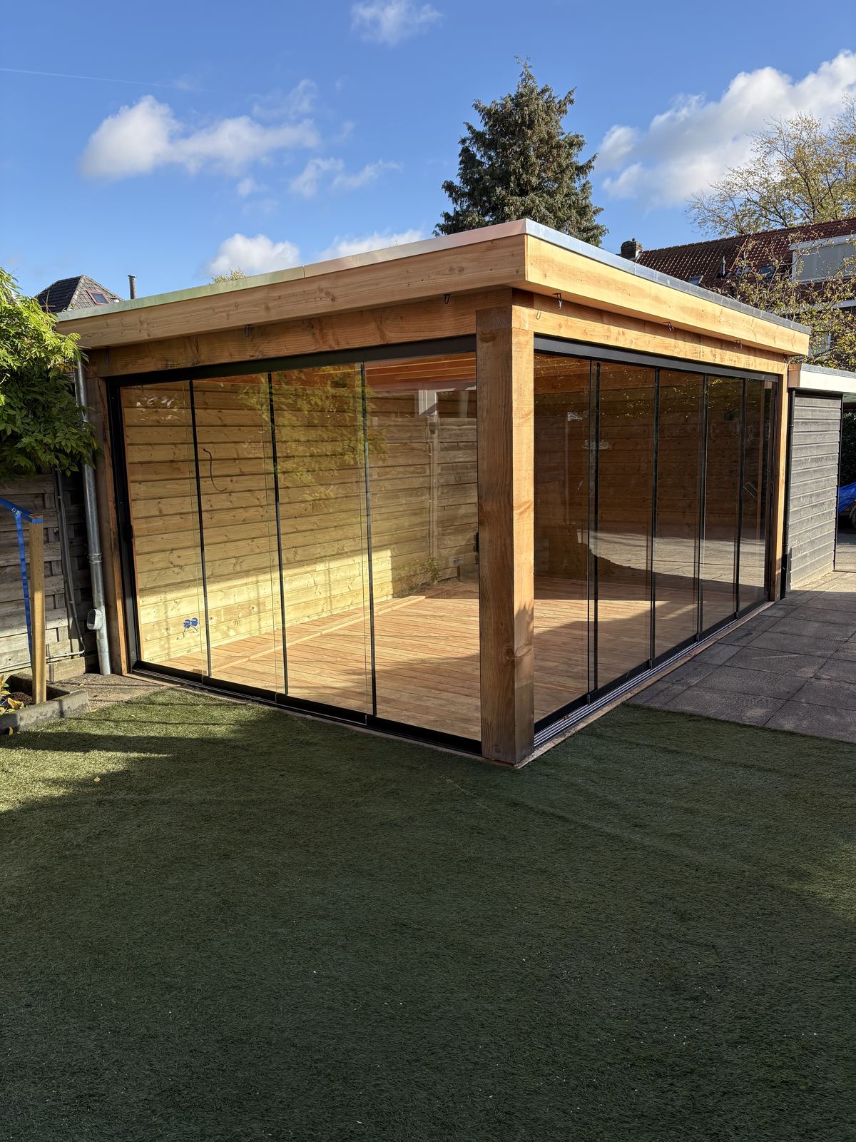 Hoekzicht glazen schuifwand bij houten constructie
