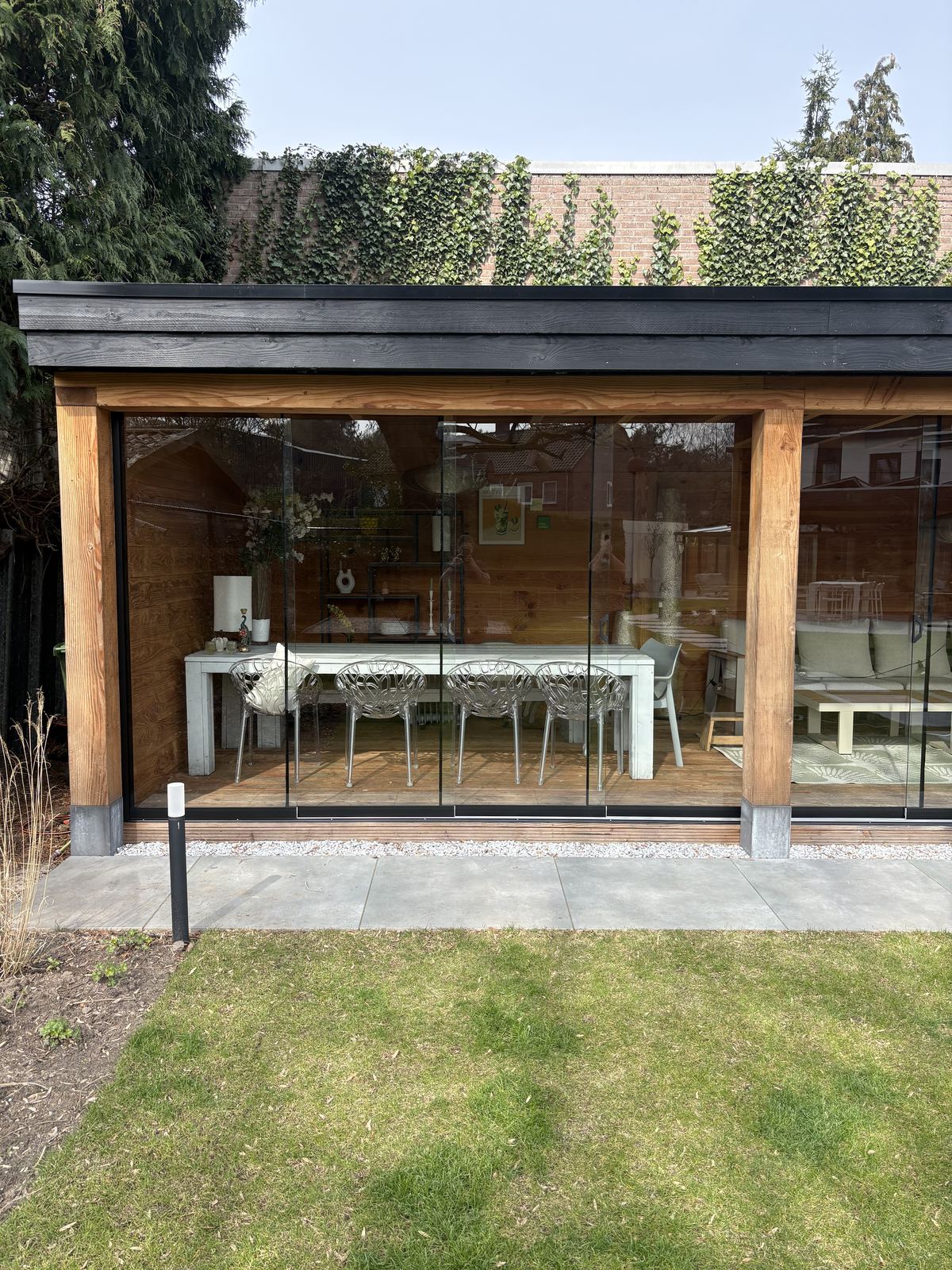 Buitenkamer met glazen wanden, breed overzicht vanuit tuin