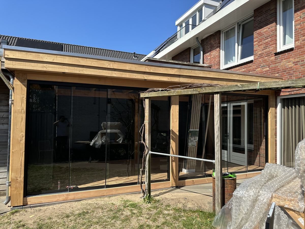 Douglas overkapping met glazen schuifwand, vlonder en zwarte achterwand